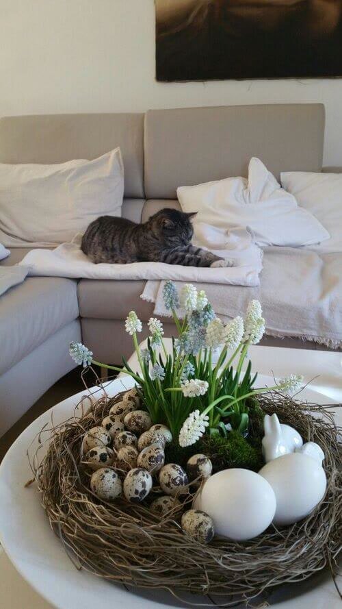 Bird's nest filled with eggs and fake flowers
