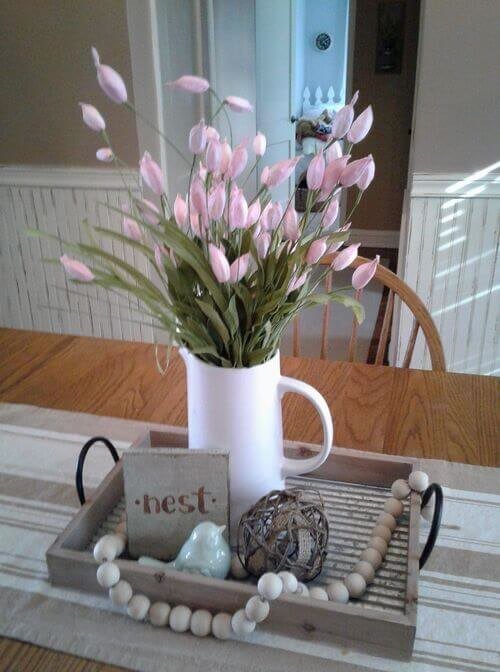 Clay pearls, ceramic birds and tulips in a jug