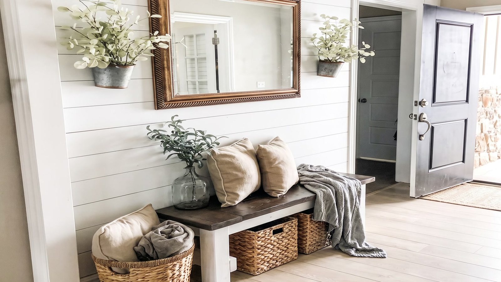 Small farmhouse entryway with a bench, baskets and mirror
