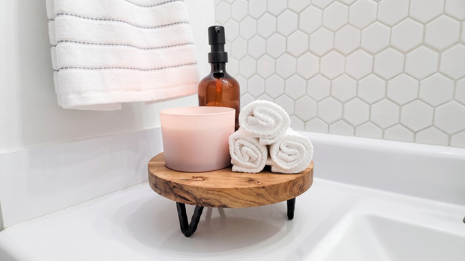 Round wood bathroom riser with candle, soap dispenser and rolled towels